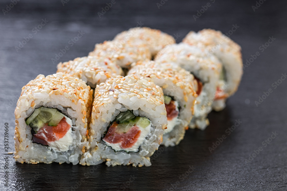 California roll with salmon arranged on slate plate background California roll with salmon arranged on slate plate background
