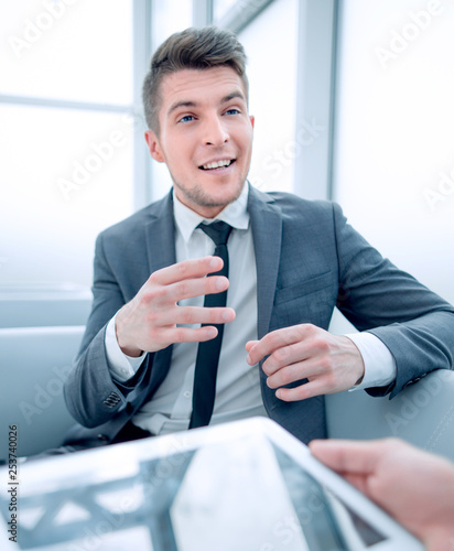 tablet in hands of businessman, man on background