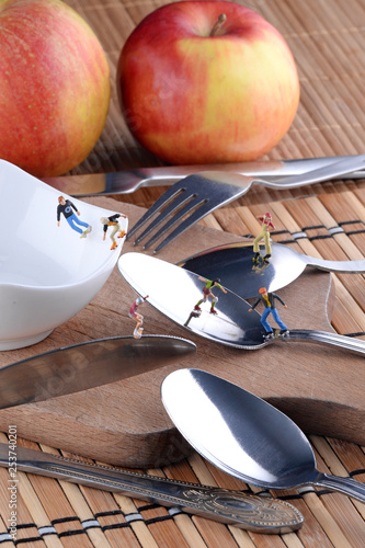 Tiny figurines skateboard on cutlery. Sport concept