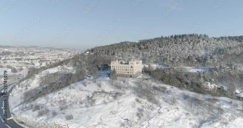 4K high angle aerial view of a beautiful snow covered forrest on Ekeberg, a popular park and recreational area in Oslo, and an old building used to train sailors before going out to sea. 4K high angle aerial view of a beautiful snow covered forrest on Ekeberg, a popular park and recreational area in Oslo, and an old building used to train sailors before going out to sea.