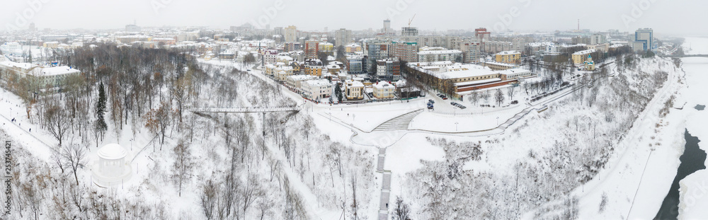 Obraz premium the city of Kirov and the high bank of the river Vyatka and the Alexander Grin Embankment and the rotunda on a cloudy winter day.