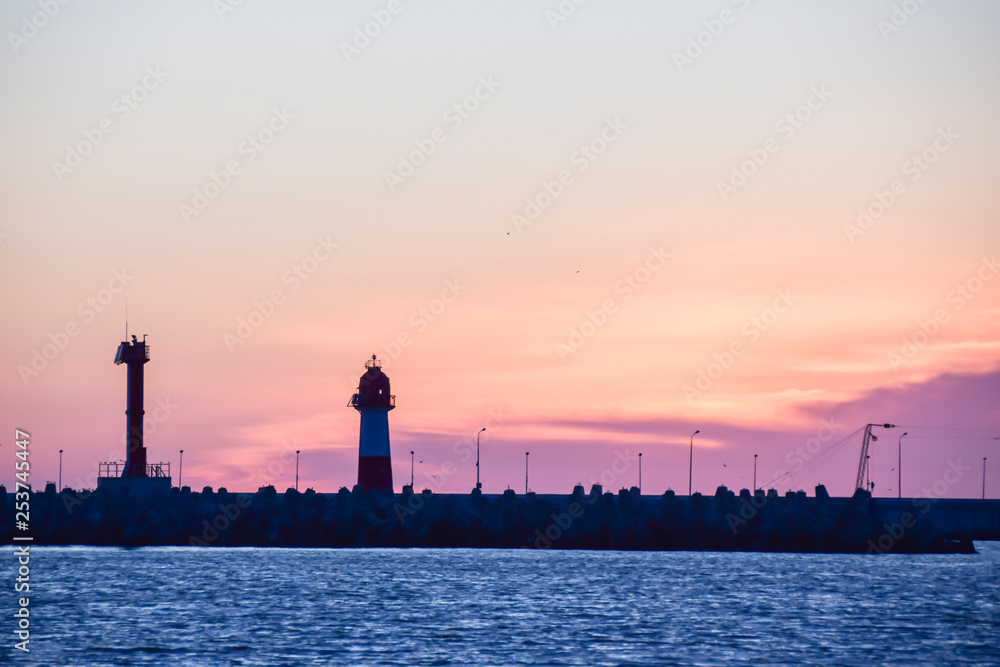 lighthouse silhouette and setting sun sunset red sky clouds