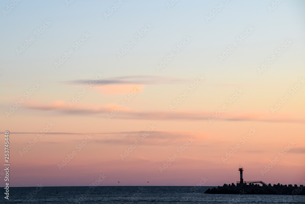 lighthouse silhouette and setting sun sunset red sky clouds