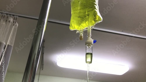 Yellow bag of intravenous chelation therapy dripping slowly in a hospital room. Close up photo