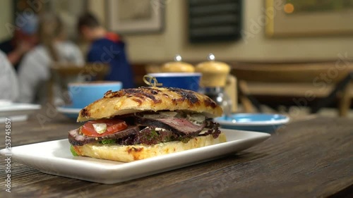 Beef sandwich for breakfast and coffees in background in stylish cafe photo