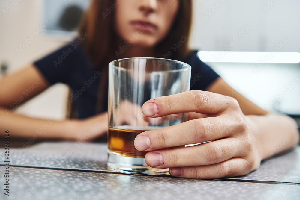 Let your hopes, not your hurts, shape your future. Addicted woman sitting in kitchen, holding a glass of whiskey. Close up Let your hopes, not your hurts, shape your future. Addicted woman sitting in kitchen, holding a glass of whiskey. Close up
