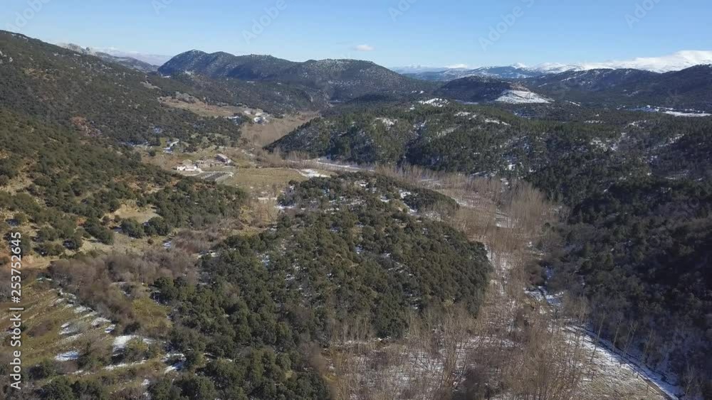 Aerial panoramic view of the stream of a river with snow and fallen leafs trees. Farm on the background. Aerial panoramic view of the stream of a river with snow and fallen leafs trees. Farm on the background.