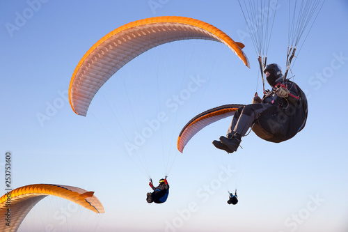 Paraglide with a paraglider in a cocoon against the background of fields of the sky and clouds. Paragliding Sports photo