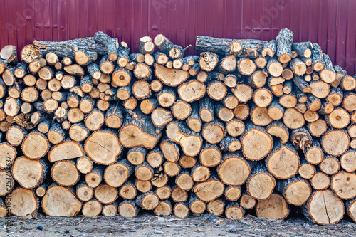 A wall of stacked firewood harvested for the winter season for heating a home and sauna
