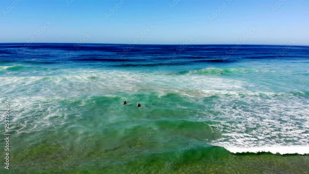 Surfers paddling out to catch waves on a magnificant day at Port Stephens Australia Surfers paddling out to catch waves on a magnificant day at Port Stephens Australia