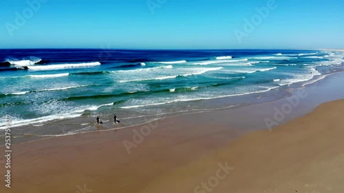 Aerial shot of a 2 surfers entering the surf at Port Stephens Australia