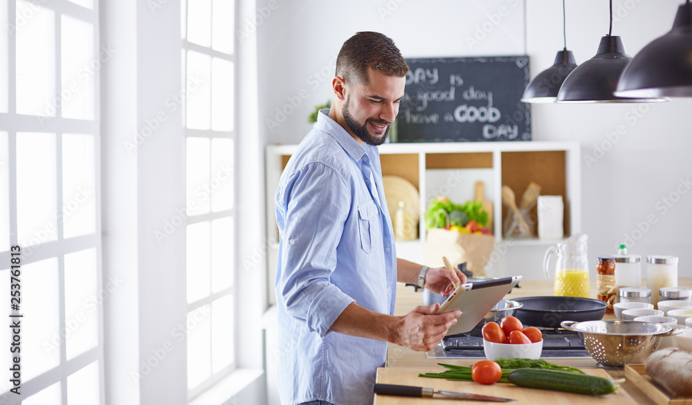 Smiling and confident chef standing in large kitchen Smiling and confident chef standing in large kitchen