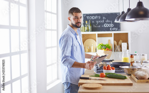 Smiling and confident chef standing in large kitchen