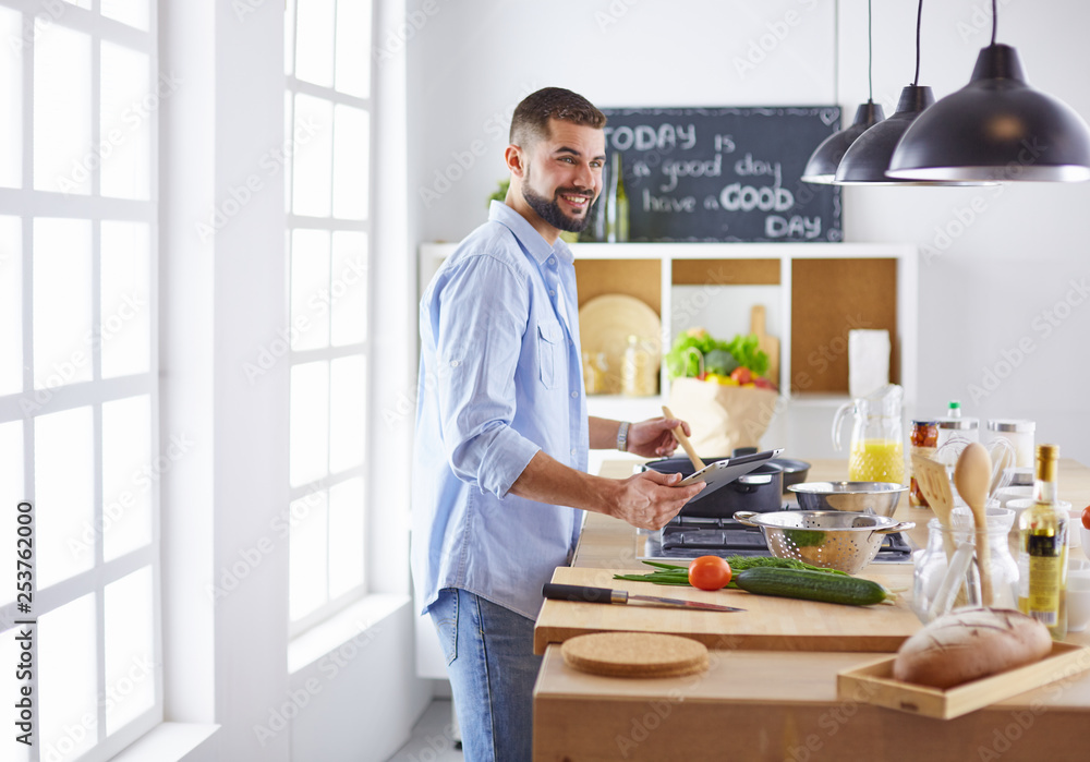 Smiling and confident chef standing in large kitchen Smiling and confident chef standing in large kitchen