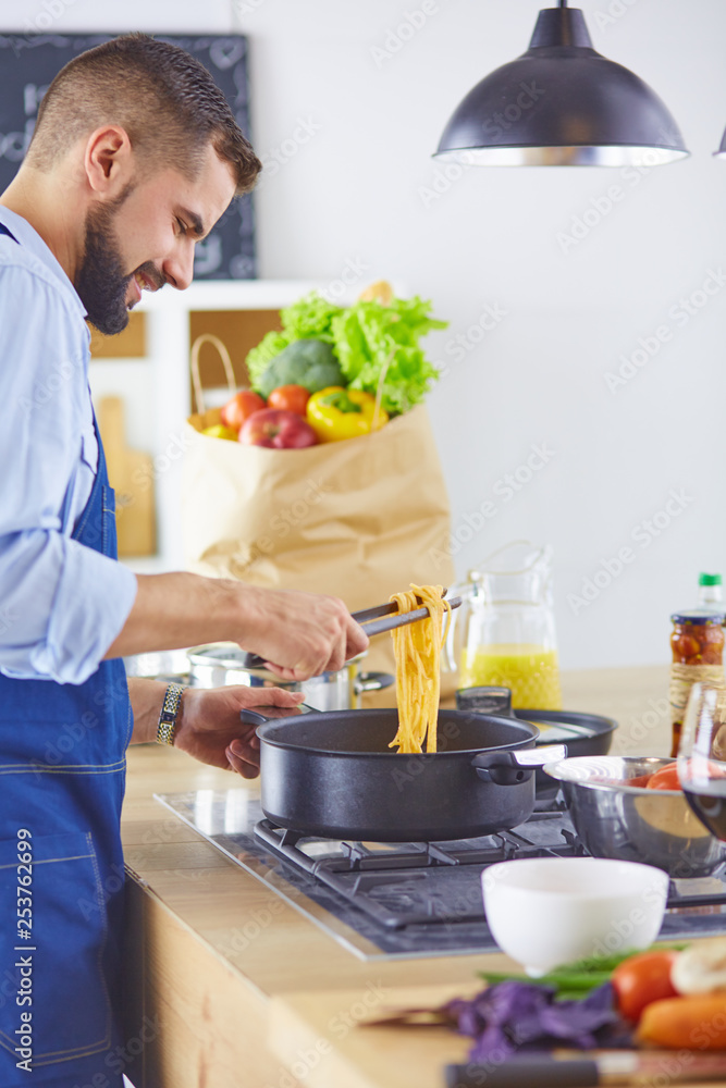 Smiling and confident chef standing in large kitchen Smiling and confident chef standing in large kitchen