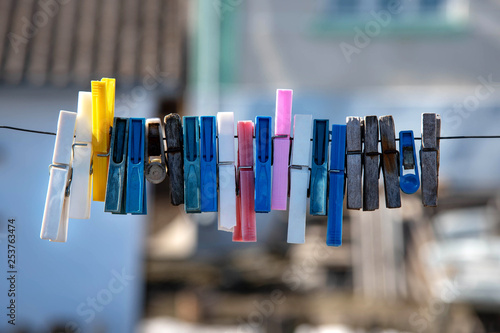 Colorful clothespin hanging on a rope. Plastic and wooden clothespins