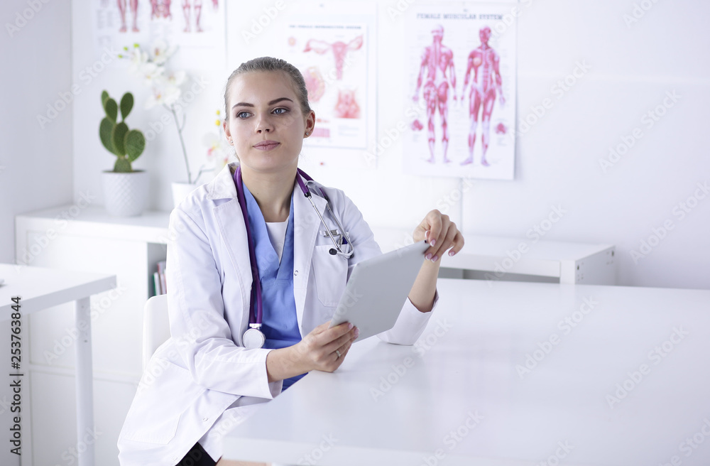 A young female doctor at a desk in the office. The concept of health and medicine