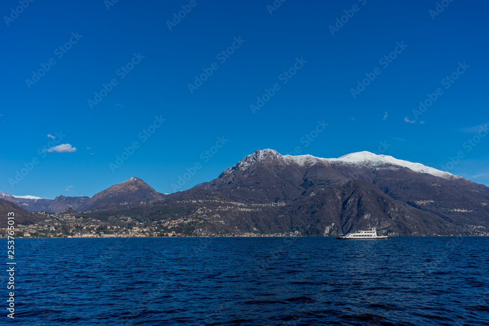 Italy, Bellagio, boat on Lake Como with snow mountain behind