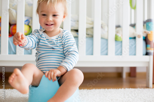Bild auf Leinwand Cute toddler boy, potty training, playing with his teddy bear
