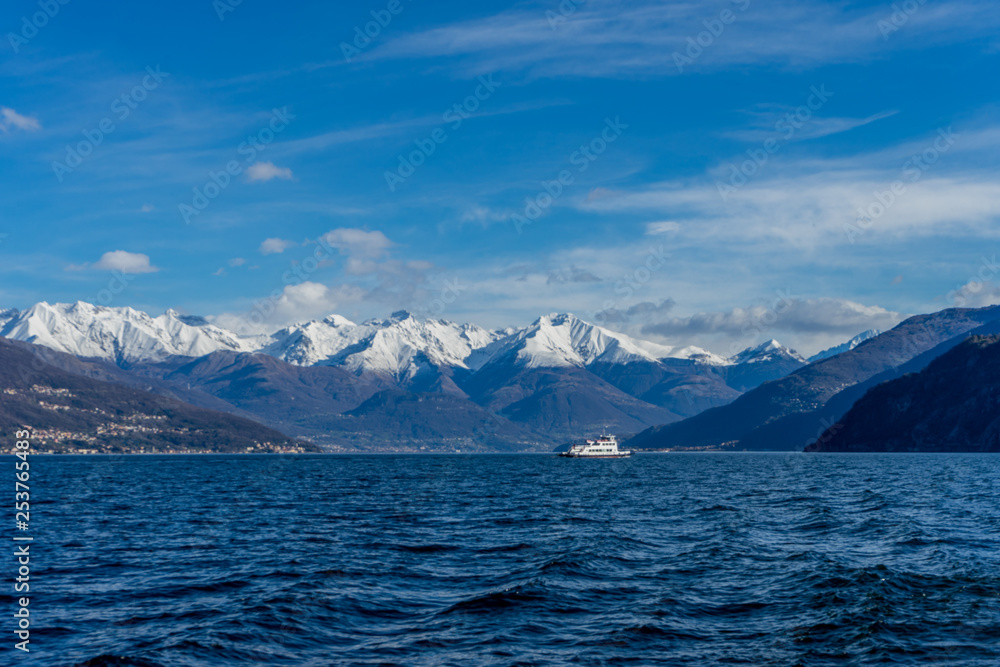 Italy, Bellagio, boat on Lake Como with snow covered peaks background