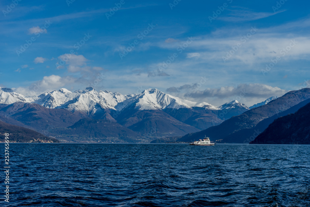 Italy, Bellagio, boat on Lake Como with snow covered peaks background
