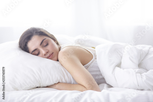 beautiful young woman basking in bed in the morning. Beautiful Model face looks sexy in camera