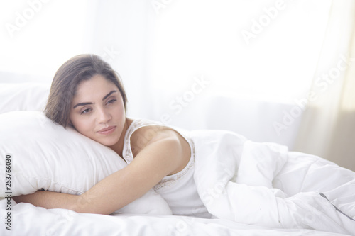 beautiful young woman basking in bed in the morning. Beautiful Model face looks sexy in camera