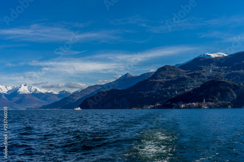 Italy, Bellagio, boat on Lake Como with snow covered peaks background