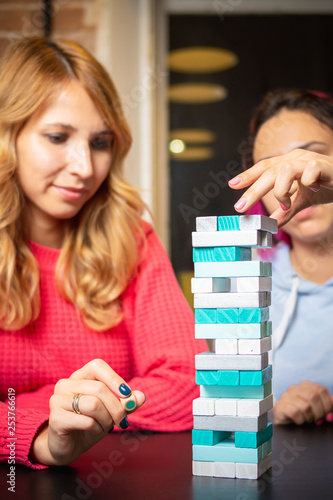 two young women playing colored jenga