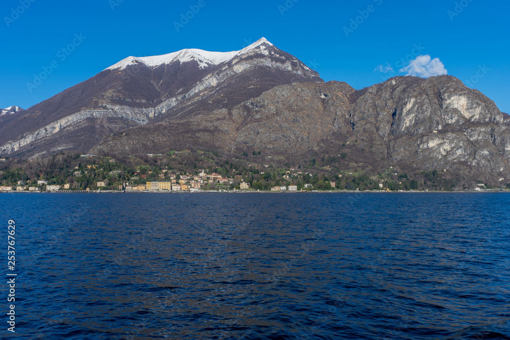 Italy, Bellagio, Lake Como, Cadenabbia, SCENIC VIEW OF SEA AND MOUNTAINS AGAINST BLUE SKY