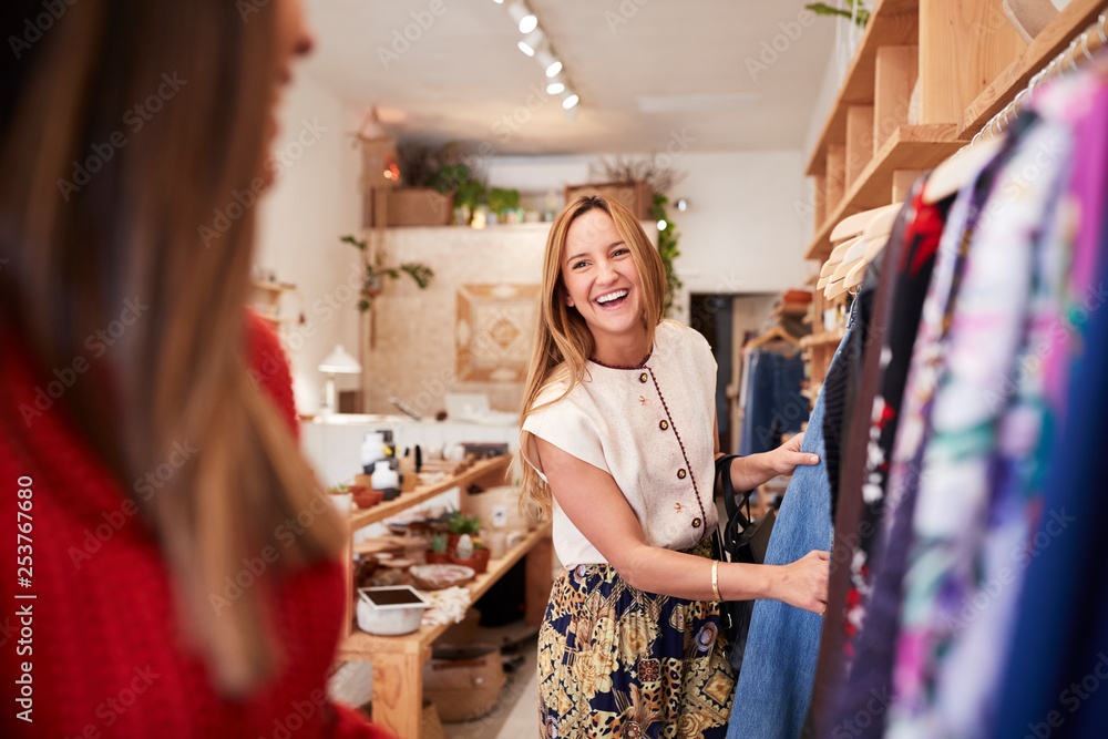 Φωτογραφία Two Female Friends Shopping In Independent Clothing Store Looking At Racks