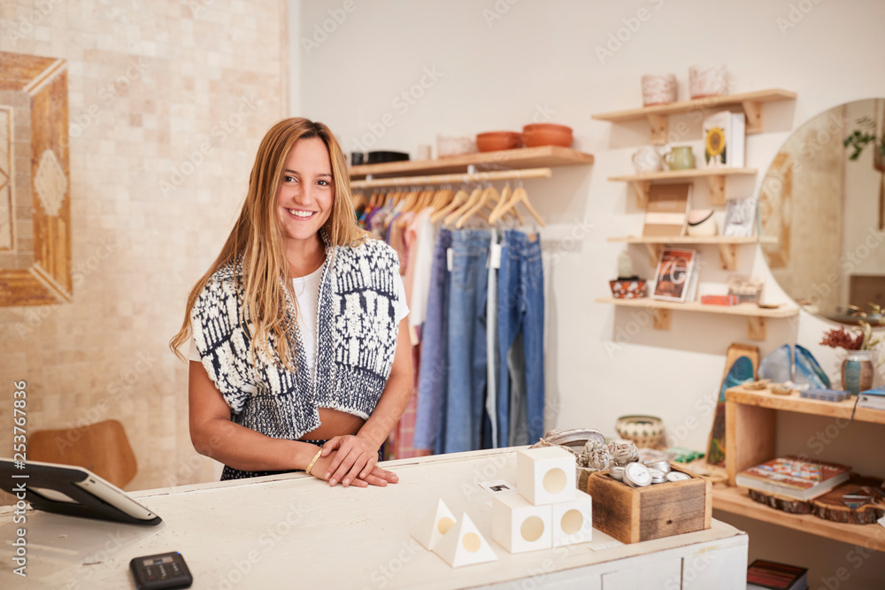 Portrait Of Female Owner Of Independent Clothing And Gift Store Behind Sales Desk