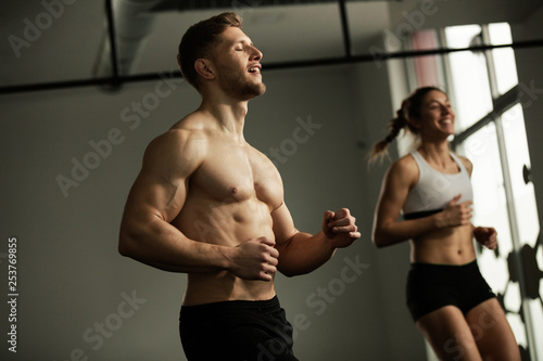 Athletic couple warming up while working out in health club.
