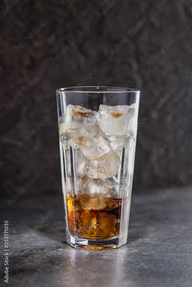 Glass of coke with ice on a dark background. Carbonated beverages. Selective fokus. Glass of coke with ice on a dark background. Carbonated beverages. Selective fokus.