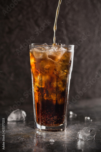 Glass of coke with ice on a dark background. Carbonated beverages. Selective fokus.