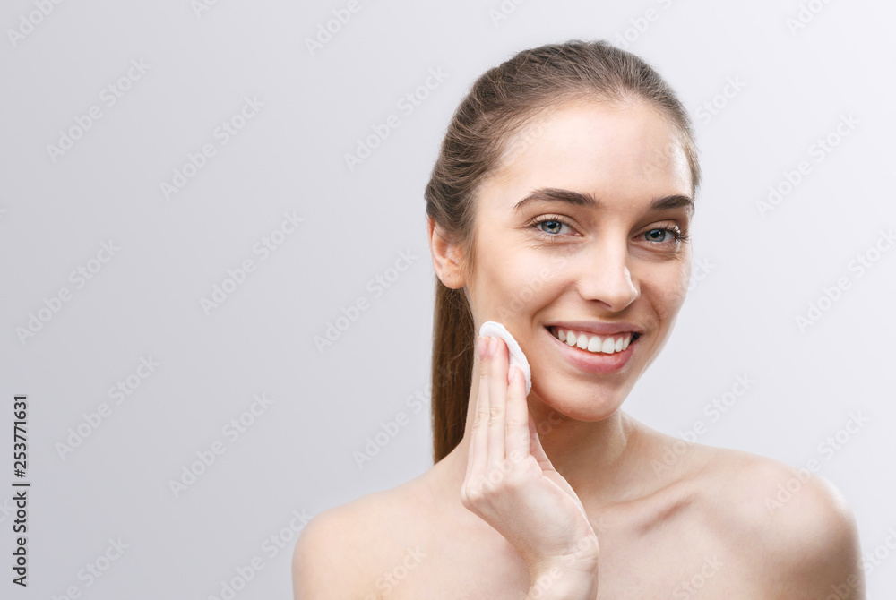 Healthy fresh girl removing makeup from her face with cotton pad Healthy fresh girl removing makeup from her face with cotton pad