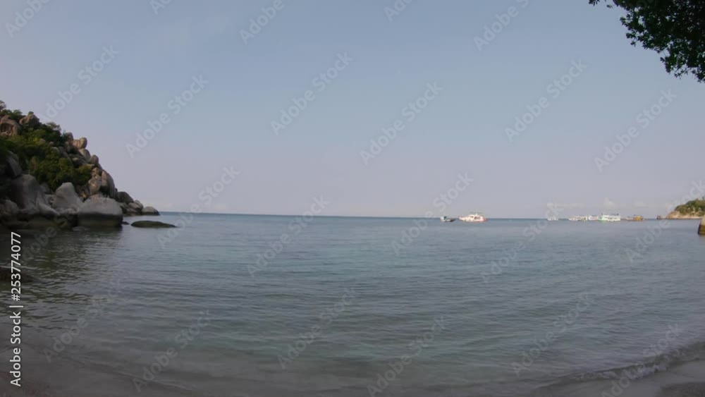 Sunrise on a peaceful lagoon with calm clear water. Boats anchored in the bay with morning sky in the background. Vacation paradise of Koh Tao, Thailand. PAN RIGHT. Sunrise on a peaceful lagoon with calm clear water. Boats anchored in the bay with morning sky in the background. Vacation paradise of Koh Tao, Thailand. PAN RIGHT.