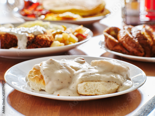 biscuits and gravy with breakfast foods on plate photo