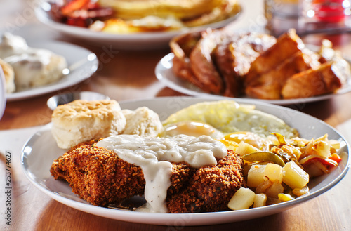 фотографія country fried steak with sunny side up eggs and biscuits