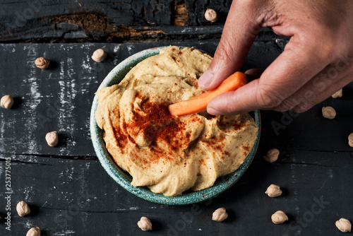 dipping carrot in a homemade hummus