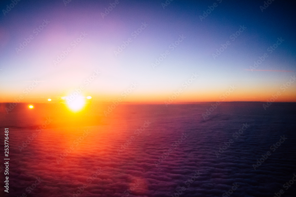 Obraz premium Sunrise above clouds from airplane