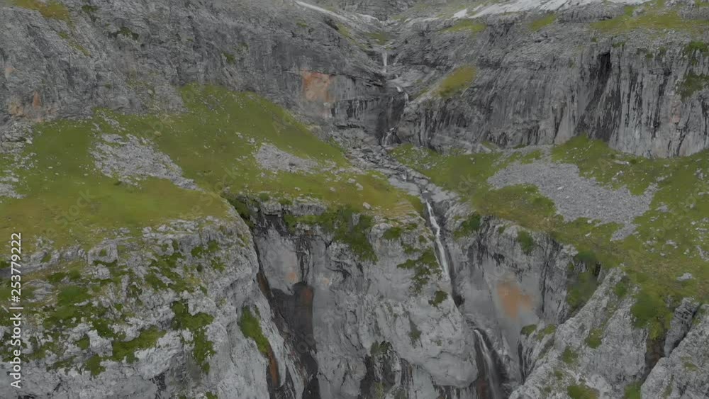 Aerial frontal view of a stream of water and a waterfall in a rocky wall over the Monte Perdido National Park in Spain. Aerial frontal view of a stream of water and a waterfall in a rocky wall over the Monte Perdido National Park in Spain.