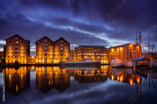 Gloucester docks at night with reflection of warehouses and boats