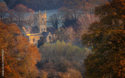 St. Eadburgha's Church in Autumn. Cotswold landscape scene at sunrise