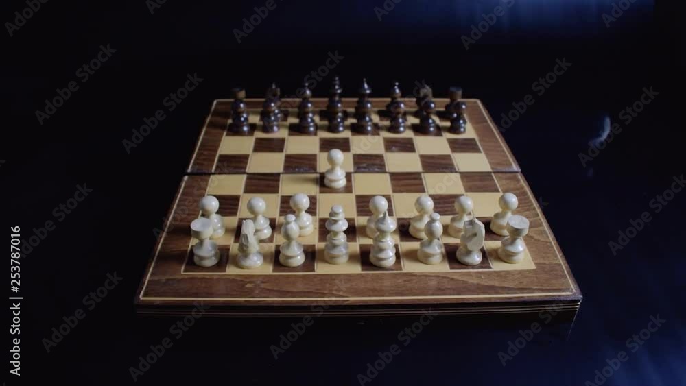 Chess players moving pawns at the beginning of the game on a black background Chess players moving pawns at the beginning of the game on a black background