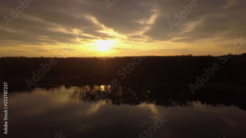 Wallpaper Mural Drone footage rising up to the left with a parallax in the water of the forest beside the pond at golden hour. Torontodigital.ca