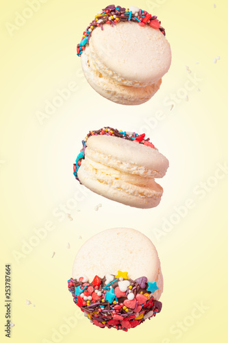 White French Macaroons, Sweet and colorful French macaroons are falling or flying in motion. On a yellow background