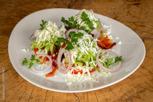 Salad with tomatoes, grated cucumbers, onion, garlic, roasted red pepper, white cow cheese and parsley.