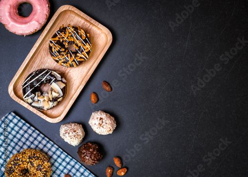 Donuts and wood on stone table.