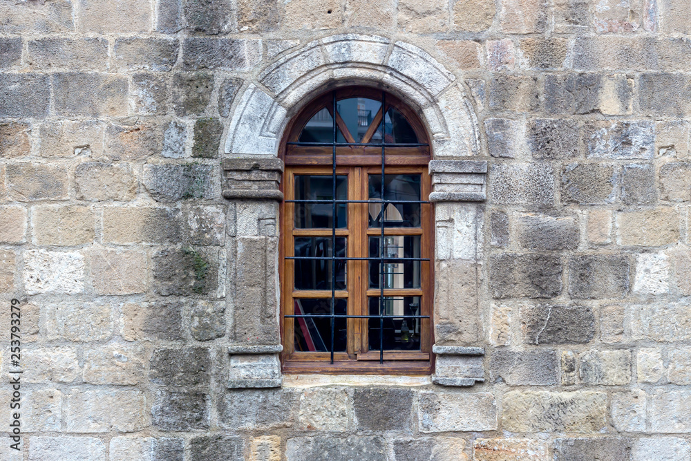 The background old beige stony wall with a window The background old beige stony wall with a window